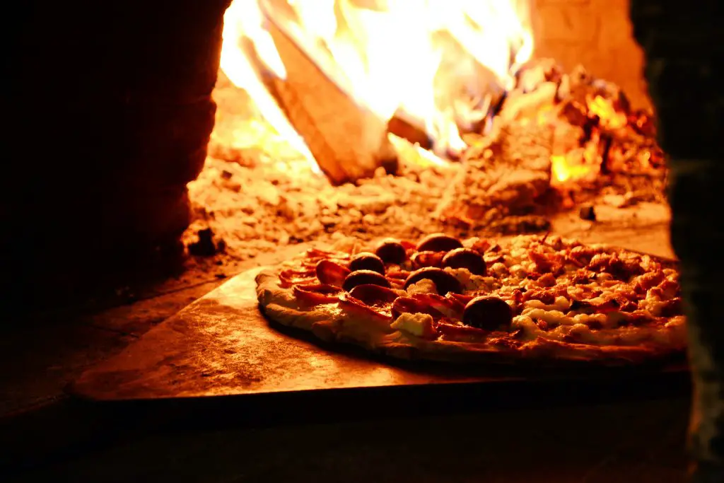 putting food into a brick pizza oven